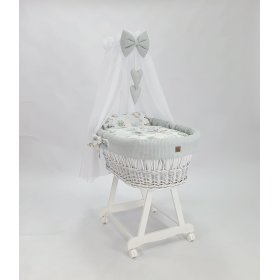 Weißes Korbbett mit Ausstattung für ein Baby - Igel